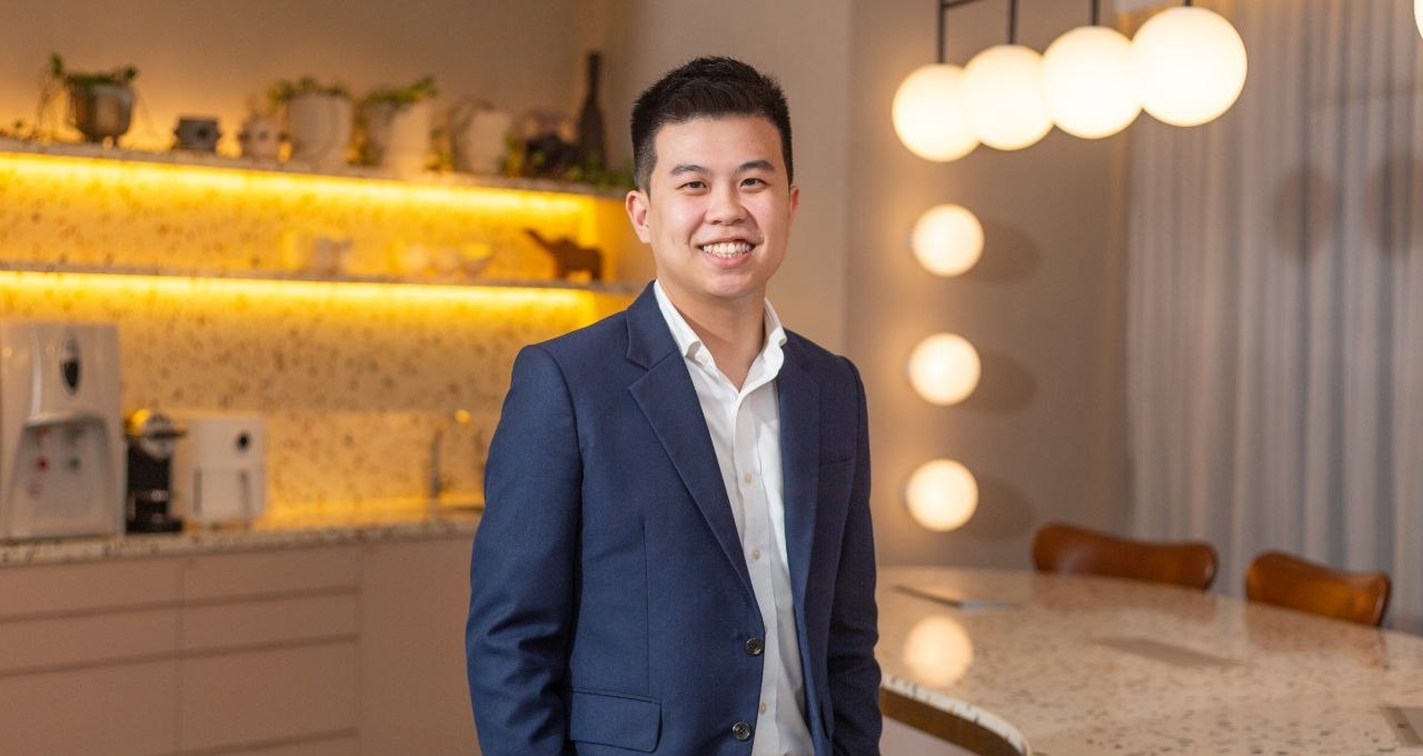 Aaron Tan, smiling, in a navy suit